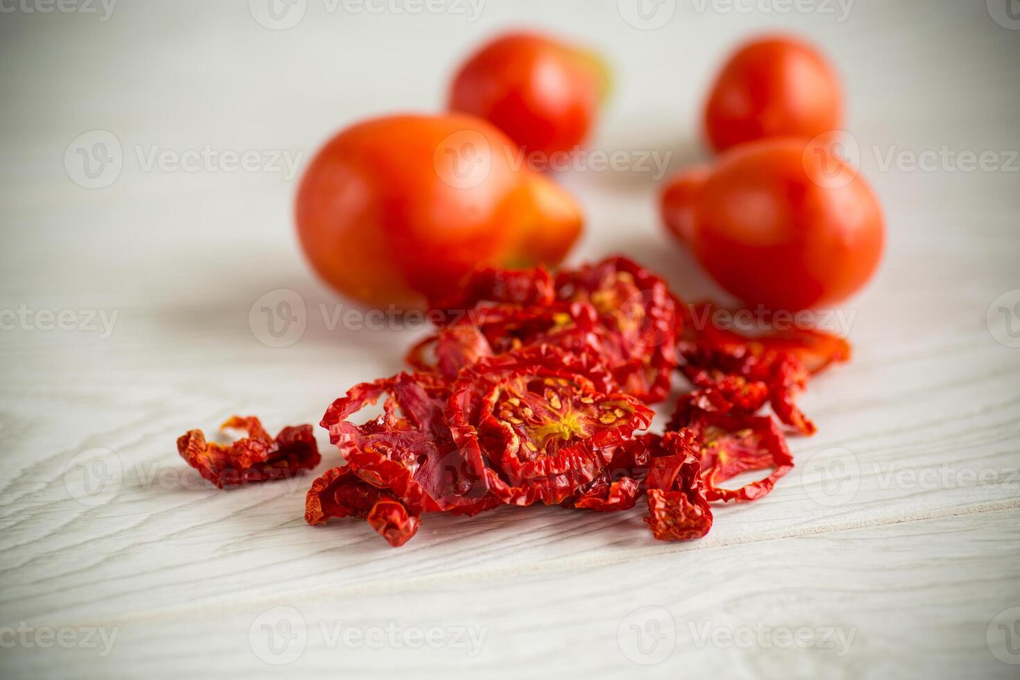 a handful of dried tomatoes and fresh tomatoes photo