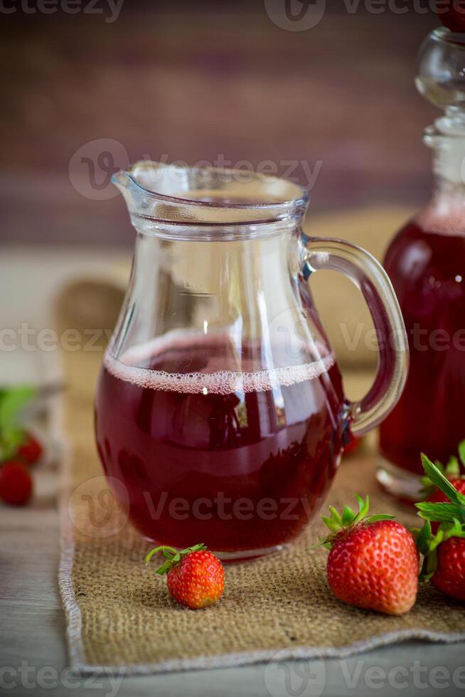 sweet cooked strawberry syrup in a glass decanter photo