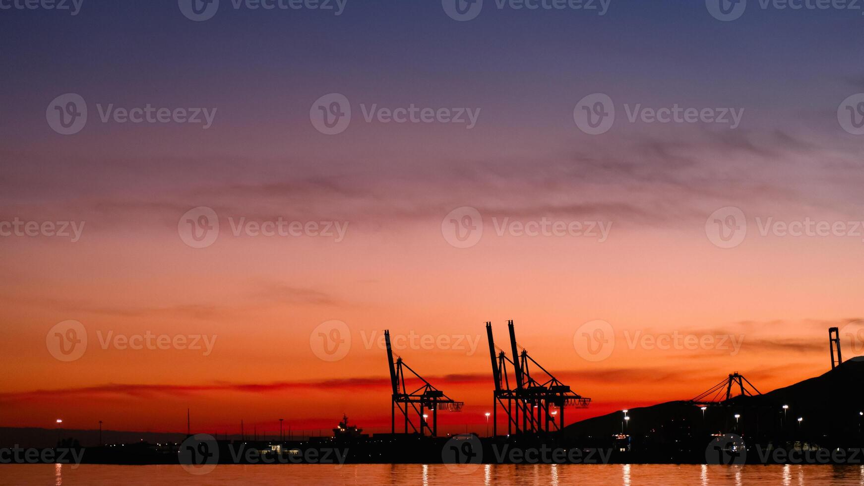 Sunset sky by the sea beach with silhouette harbour and blurry twilight Dusk sky in Evening in orange, red, purple, blue with cloud,Horizon Nature Golden Sky,Beautiful Sunrise background photo