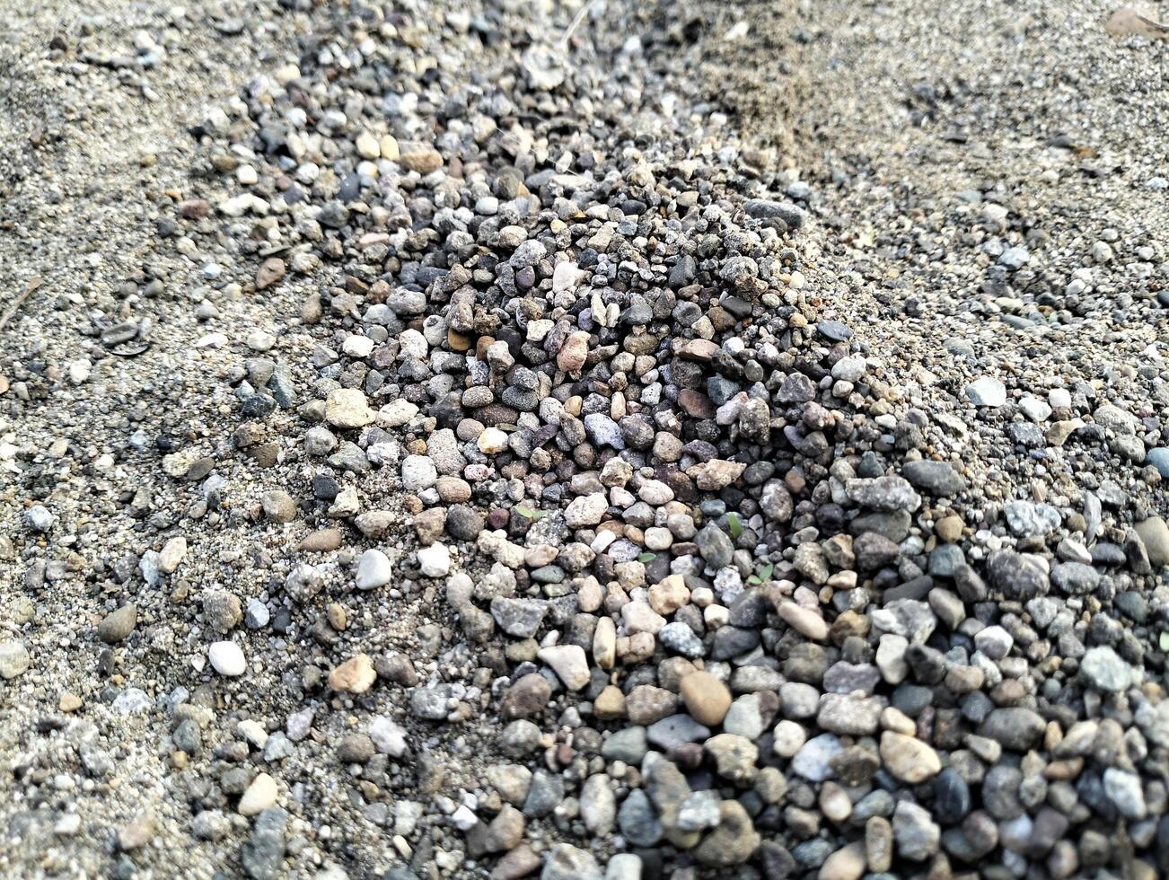 Gray gravel stones for the construction industry. Mound of granite gravel, stones, crushed stone close-up. Rough seamless texture, construction material background. photo