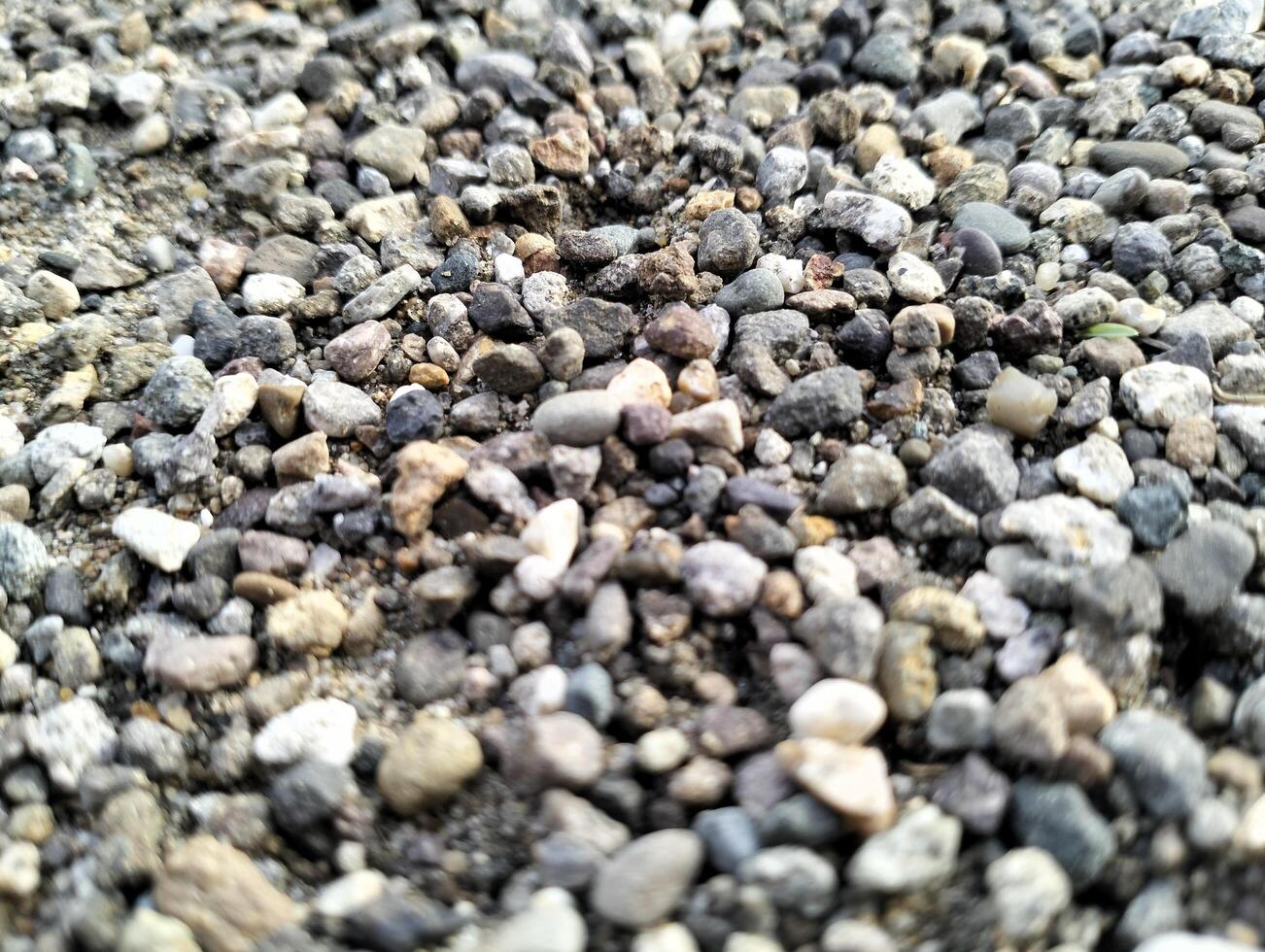 Gray gravel stones for the construction industry. Mound of granite gravel, stones, crushed stone close-up. Rough seamless texture, construction material background. photo