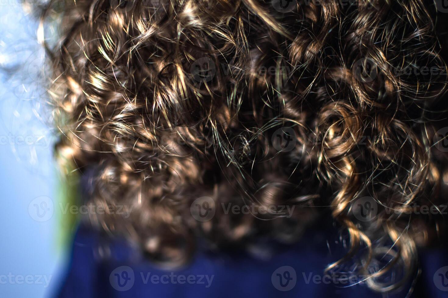 Natural curly hair, little girl with light brown curls and golden reflections photo