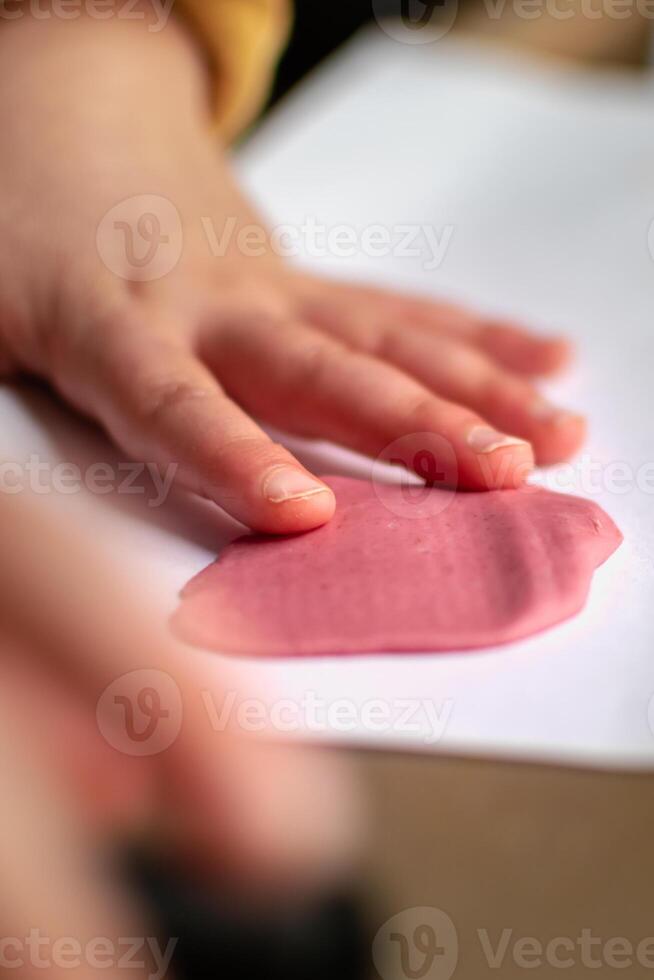 Child having fun modeling salt dough, authentic activity with natural pink coloring beet juice, fine motor skills development photo