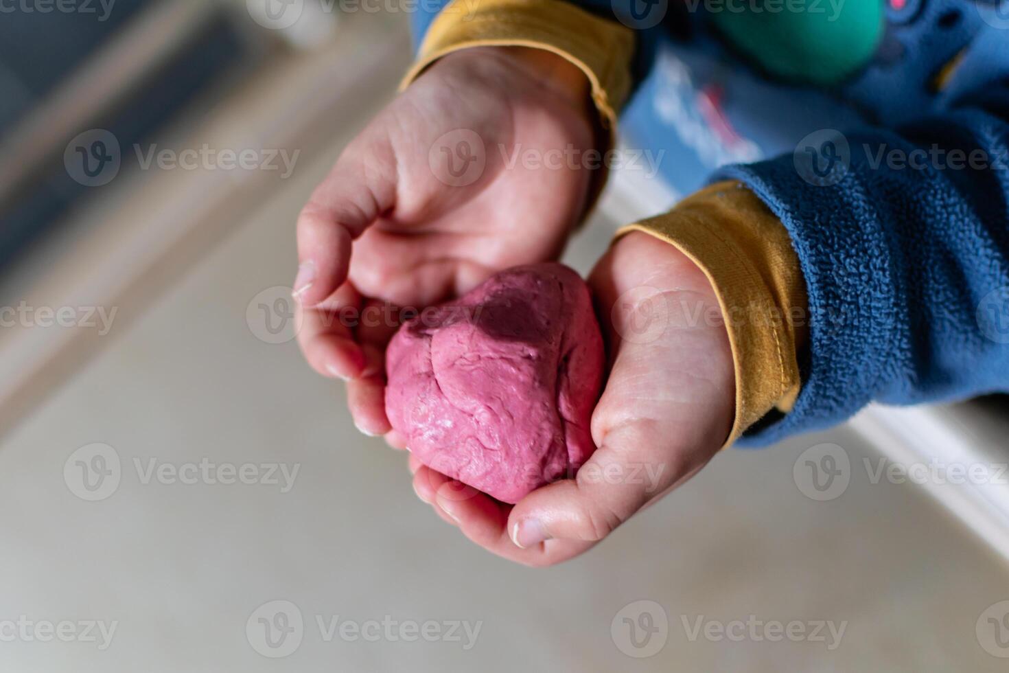 niño teniendo divertido modelado sal masa, auténtico actividad con natural rosado colorante remolacha jugo, multa motor habilidades desarrollo foto