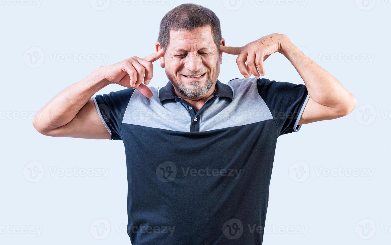 Displeased senior man covering his ears isolated. Older people ignoring and covering ears photo