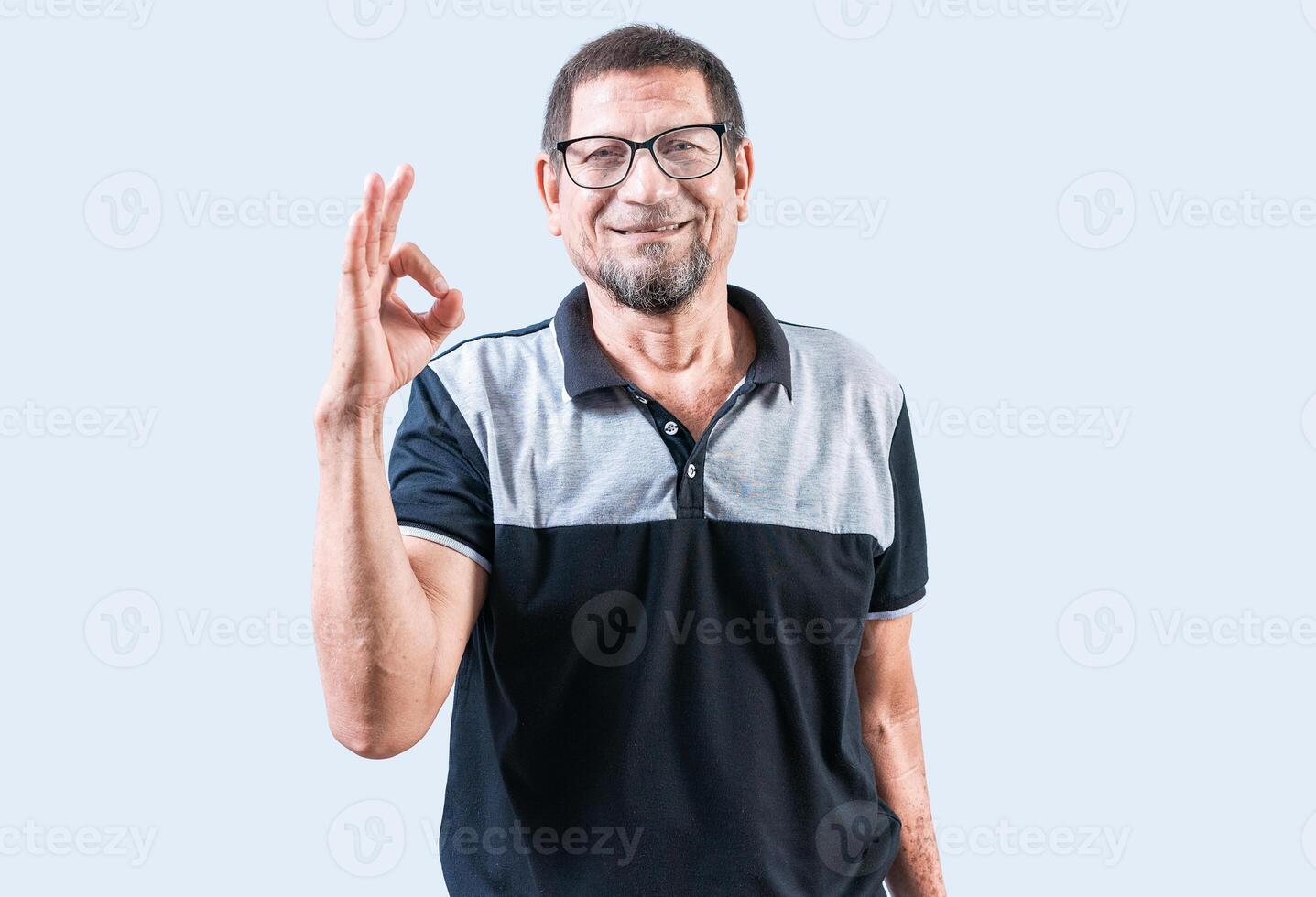 Smiling elderly man gesturing OK isolated. Cheerful old man gesturing approved on white backgroud photo