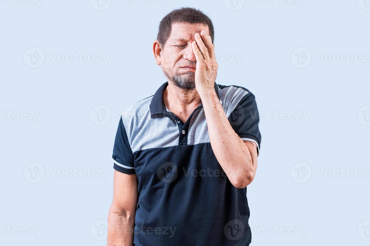 Tired and exhausted old man covering his face with the palm of his hand. Exhausted senior man putting the palm on his face photo