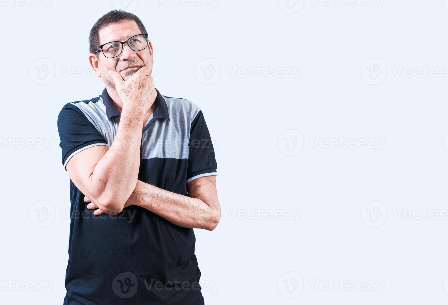 Elderly man thinking with hand on chin isolated. Pensive old man in glasses with hand on chin photo