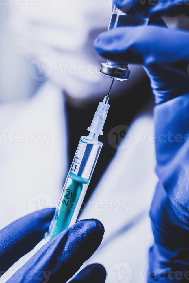 Syringe and hand closeup. The concept of vaccination, filling the drug into the syringe photo