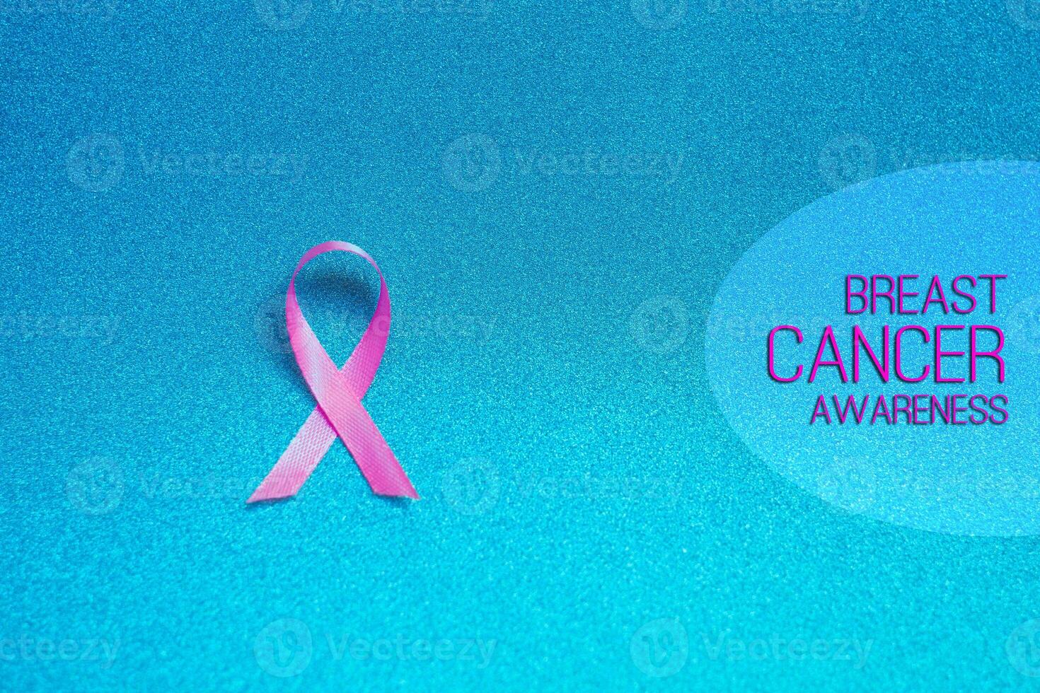 Pink ribbon for text Breast Cancer Awareness, symbolic bow color raising awareness on people living with women's breast tumor illness. bow isolated with clipping glitter blue background photo