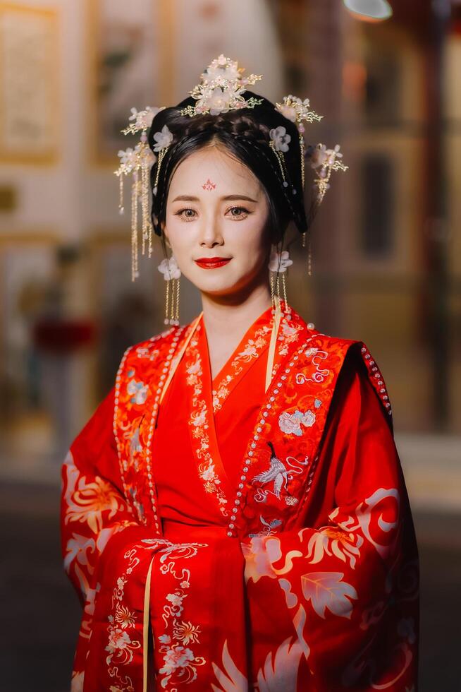 Woman dress China New year. portrait of a woman. person in traditional costume. woman in traditional costume. Beautiful young woman in a bright red dress and a crown of Chinese Queen posing. photo