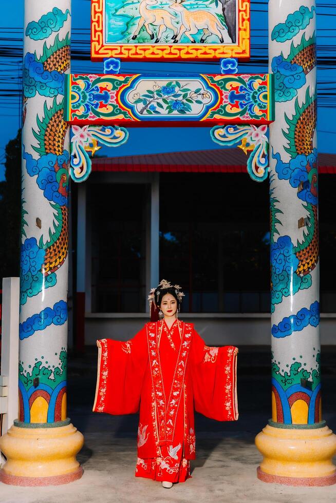 mujer vestir China nuevo año. retrato de un mujer. persona en tradicional traje. mujer en tradicional traje. hermosa joven mujer en un brillante rojo vestir y un corona de chino reina posando foto