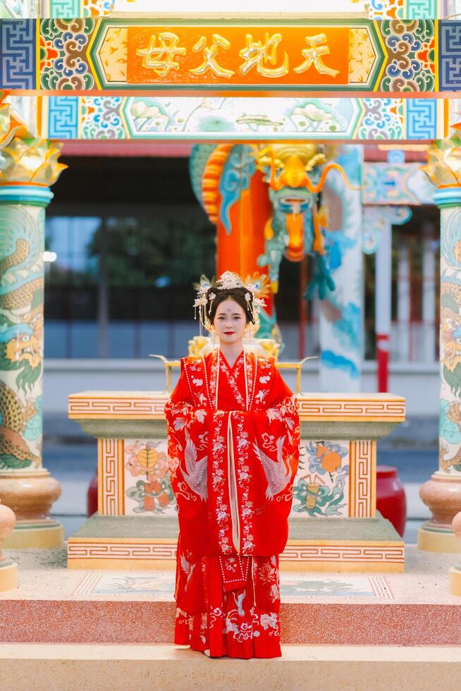 mujer vestir China nuevo año. retrato de un mujer. persona en tradicional traje. mujer en tradicional traje. hermosa joven mujer en un brillante rojo vestir y un corona de chino reina posando foto