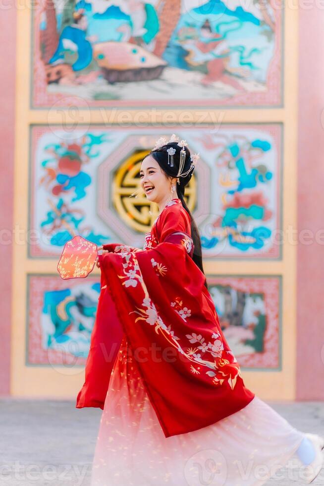 mujer vestir China nuevo año. retrato de un mujer. persona en tradicional traje. mujer en tradicional traje. hermosa joven mujer en un brillante rojo vestir y un corona de chino reina posando foto