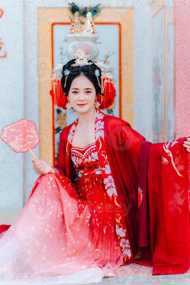 Woman dress China New year. portrait of a woman. person in traditional costume. woman in traditional costume. Beautiful young woman in a bright red dress and a crown of Chinese Queen posing. photo