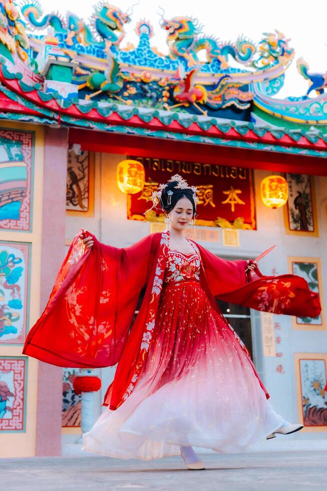 mujer vestir China nuevo año. retrato de un mujer. persona en tradicional traje. mujer en tradicional traje. hermosa joven mujer en un brillante rojo vestir y un corona de chino reina posando foto