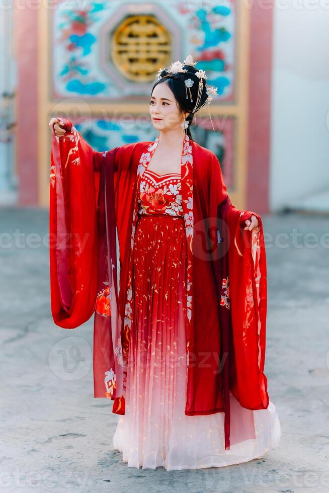 mujer vestir China nuevo año. retrato de un mujer. persona en tradicional traje. mujer en tradicional traje. hermosa joven mujer en un brillante rojo vestir y un corona de chino reina posando foto