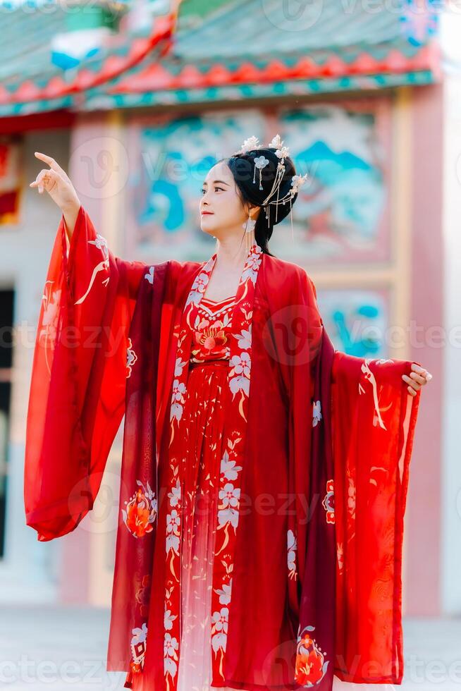 mujer vestir China nuevo año. retrato de un mujer. persona en tradicional traje. mujer en tradicional traje. hermosa joven mujer en un brillante rojo vestir y un corona de chino reina posando foto