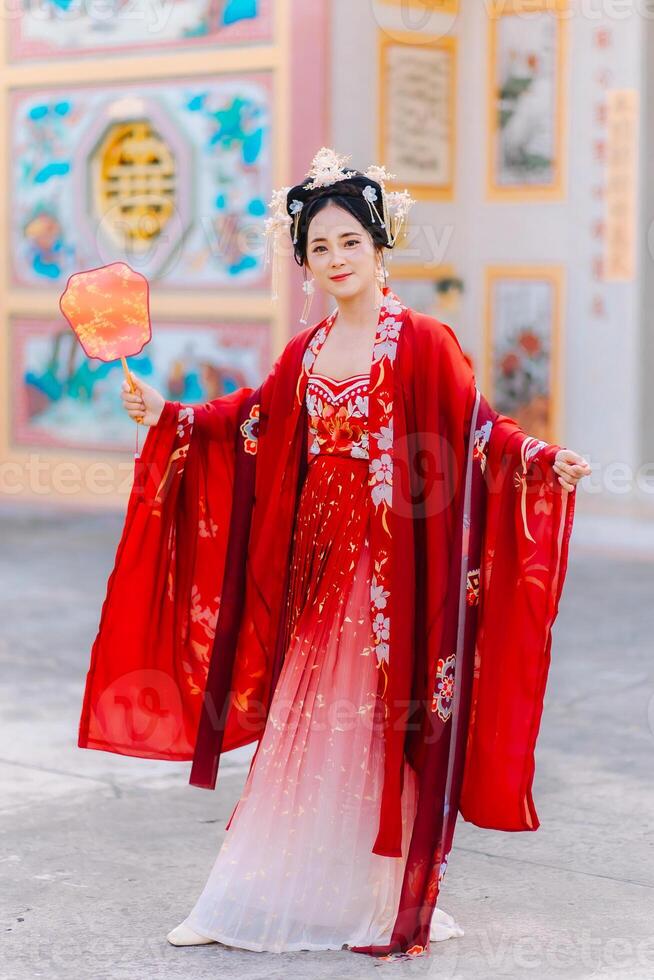 mujer vestir China nuevo año. retrato de un mujer. persona en tradicional traje. mujer en tradicional traje. hermosa joven mujer en un brillante rojo vestir y un corona de chino reina posando foto