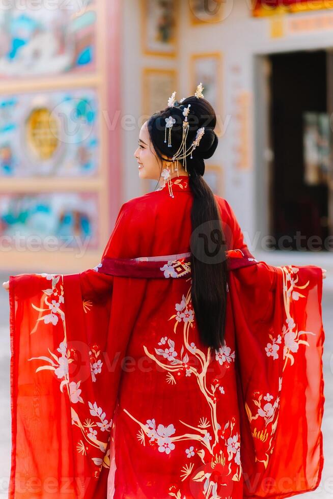 Woman dress China New year. portrait of a woman. person in traditional costume. woman in traditional costume. Beautiful young woman in a bright red dress and a crown of Chinese Queen posing. photo