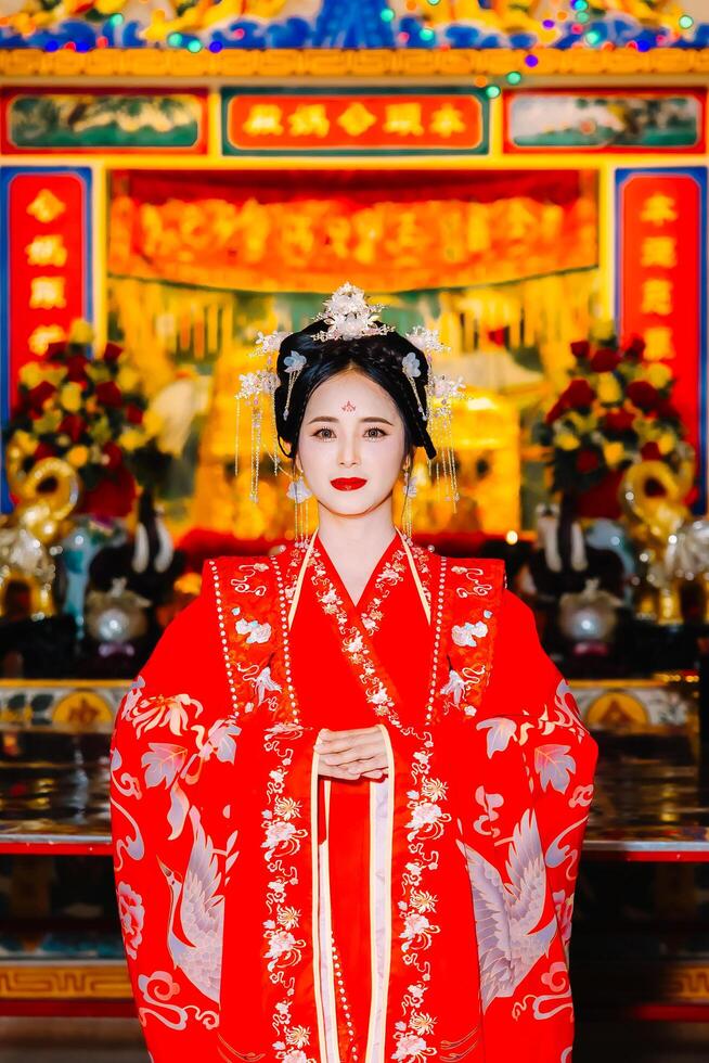 Woman dress China New year. portrait of a woman. person in traditional costume. woman in traditional costume. Beautiful young woman in a bright red dress and a crown of Chinese Queen posing. photo