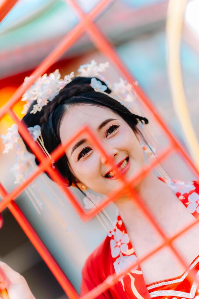 mujer vestir China nuevo año. retrato de un mujer. persona en tradicional traje. mujer en tradicional traje. hermosa joven mujer en un brillante rojo vestir y un corona de chino reina posando foto