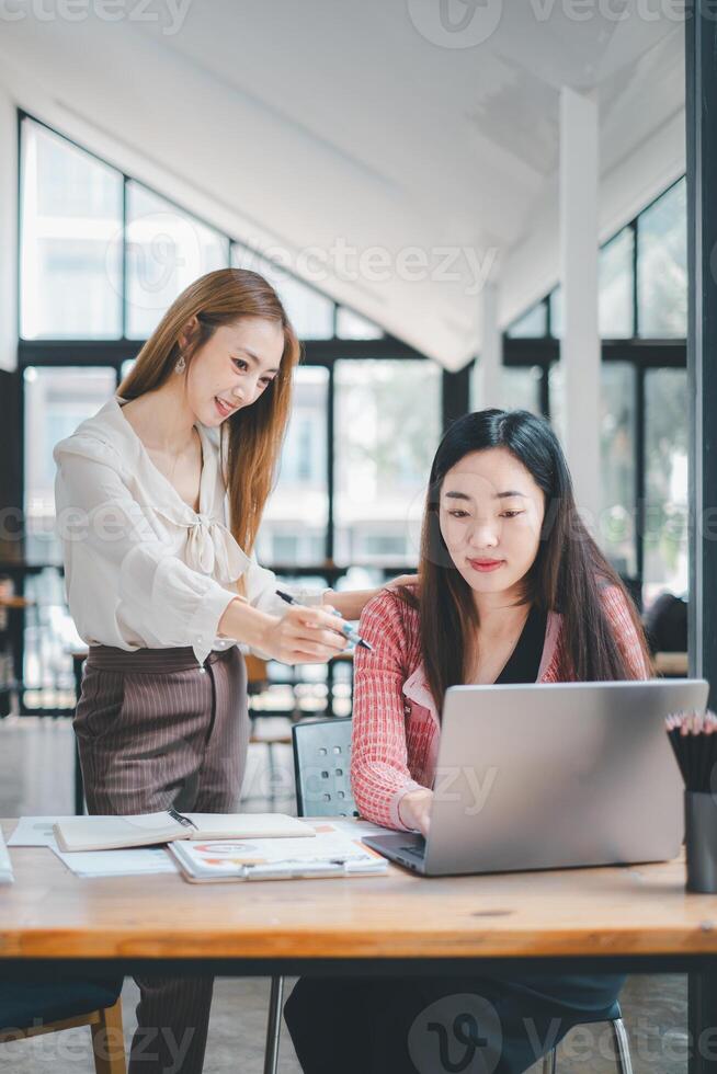 negocio equipo concepto, enfocado equipo miembros evaluar información en un ordenador portátil mientras que se discute su negocio estrategia en un moderno espacio de trabajo foto