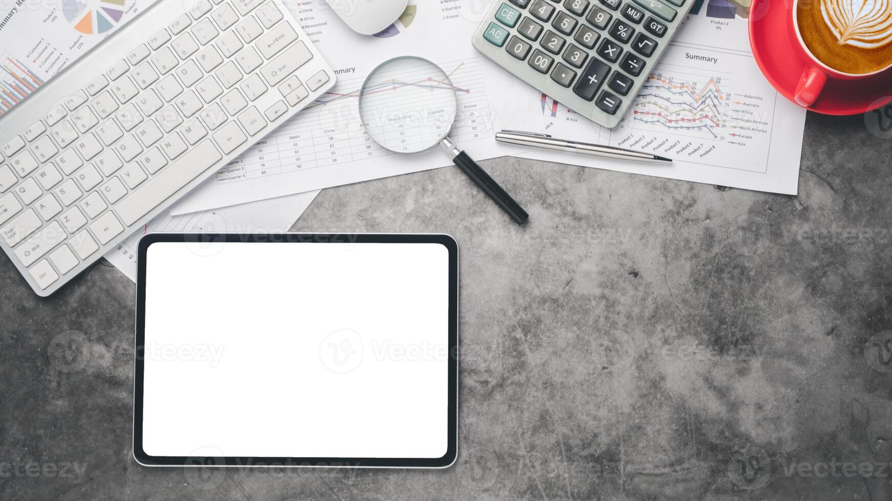 Tablet with charts and reports on office desk workplace. Top view flat lay photo