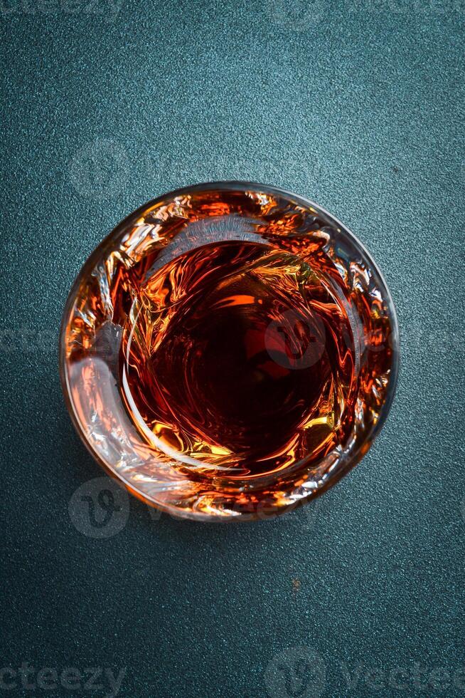 A glass of dark rum. Close up, top view. Strong aged alcoholic drinks. photo
