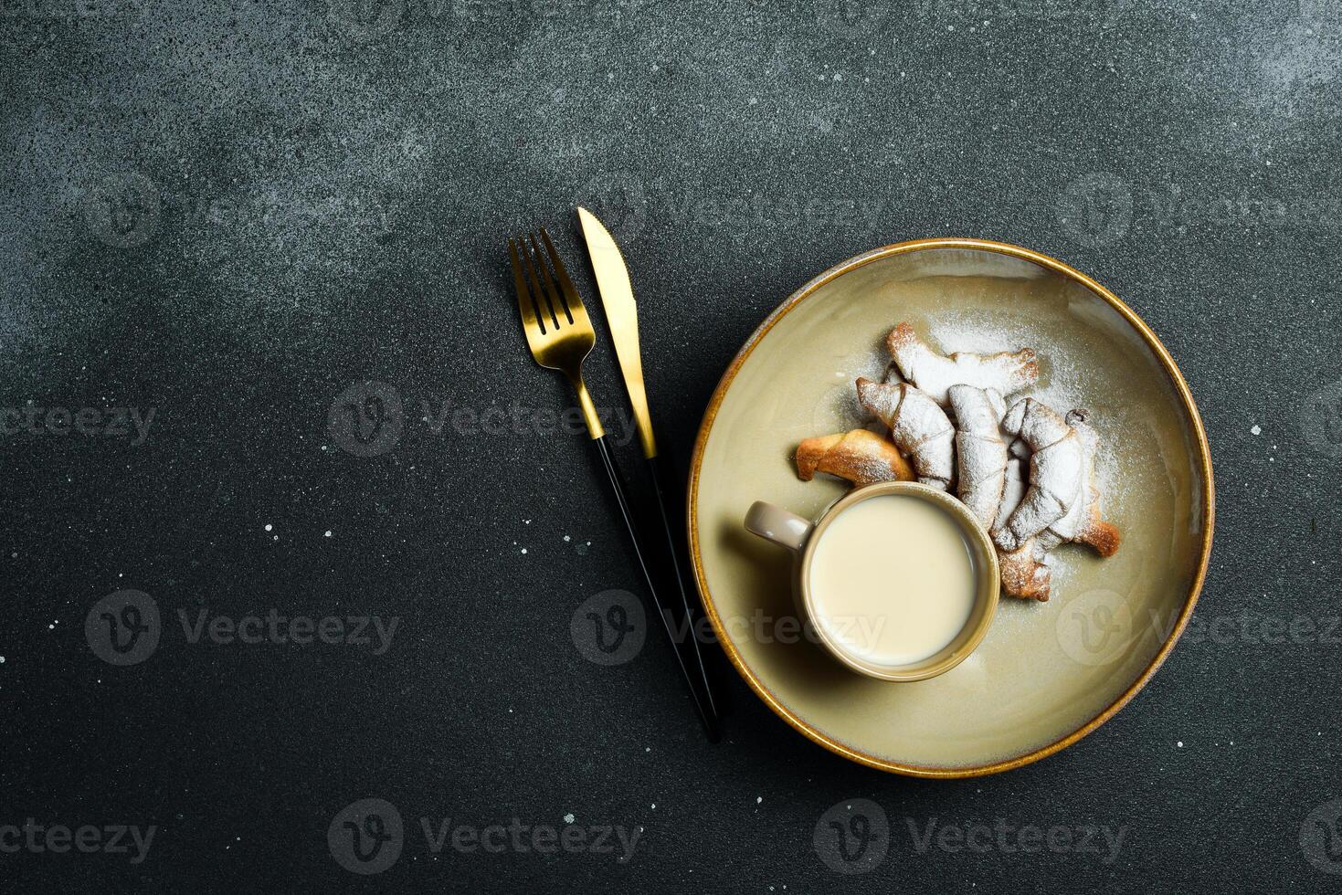 Baking. Mini croissants with jam and powdered sugar. On a black stone background. Free space for text. photo