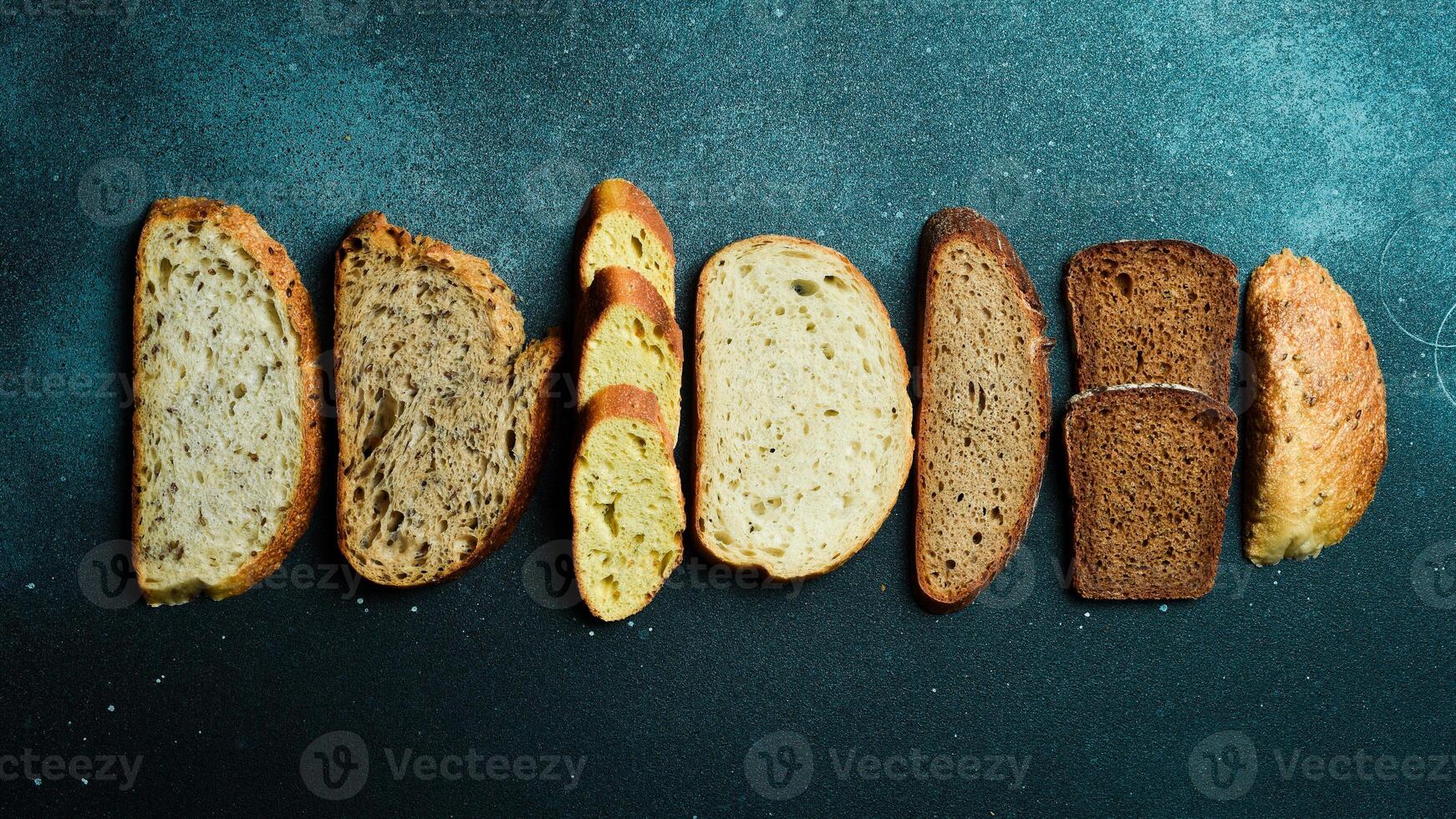 Slices of different types of bread. Assortment of rye, bran and sourdough bread. Top view. photo