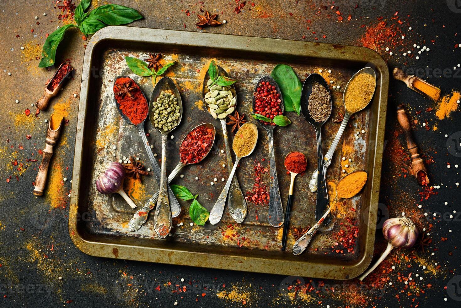 Aromatic Indian spices in spoons on a metal tray. Background of spices. Top view. photo