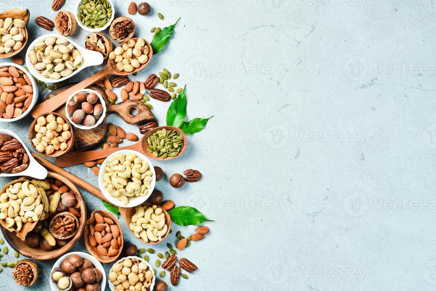 Assortment of nuts in bowls. Cashew, hazelnuts, walnuts, pistachio, pecans, pine nuts, peanut. Food mix background, top view, copy space. photo