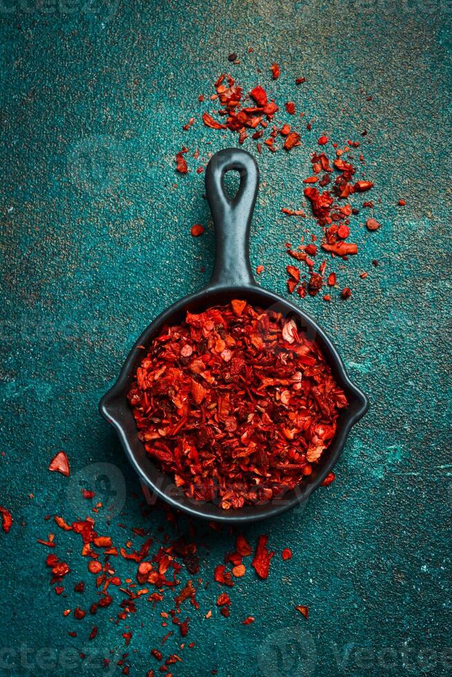 Dried red hot pepper in a bowl. Spices and condiments. Top view. On a textured background. photo