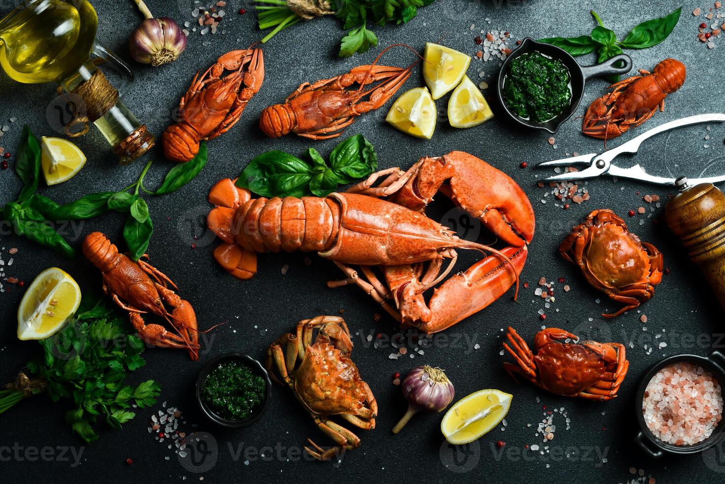 grilled lobster with lemon and basil on a black slate board. on a dark wooden table photo