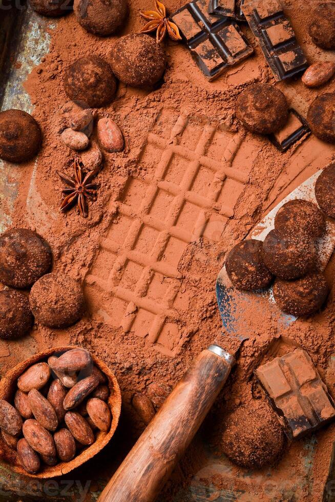 Sweet chocolate truffles with cocoa powder. On a dark chocolate background. Cocoa beans. photo