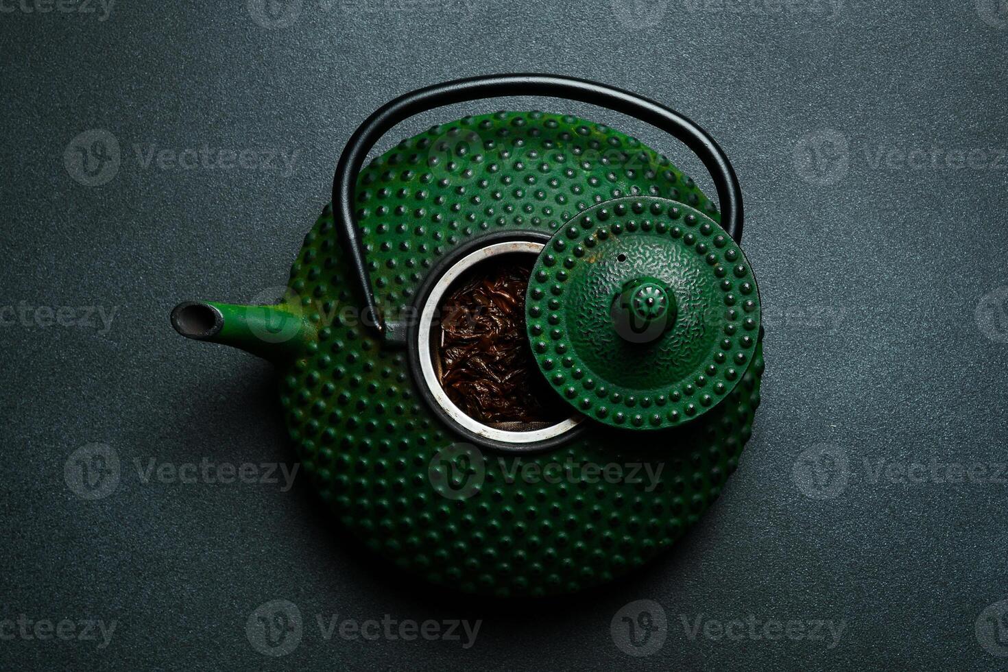 Traditional Japanese teapot for brewing tea. On a black stone background. Top view. Free space for text. photo