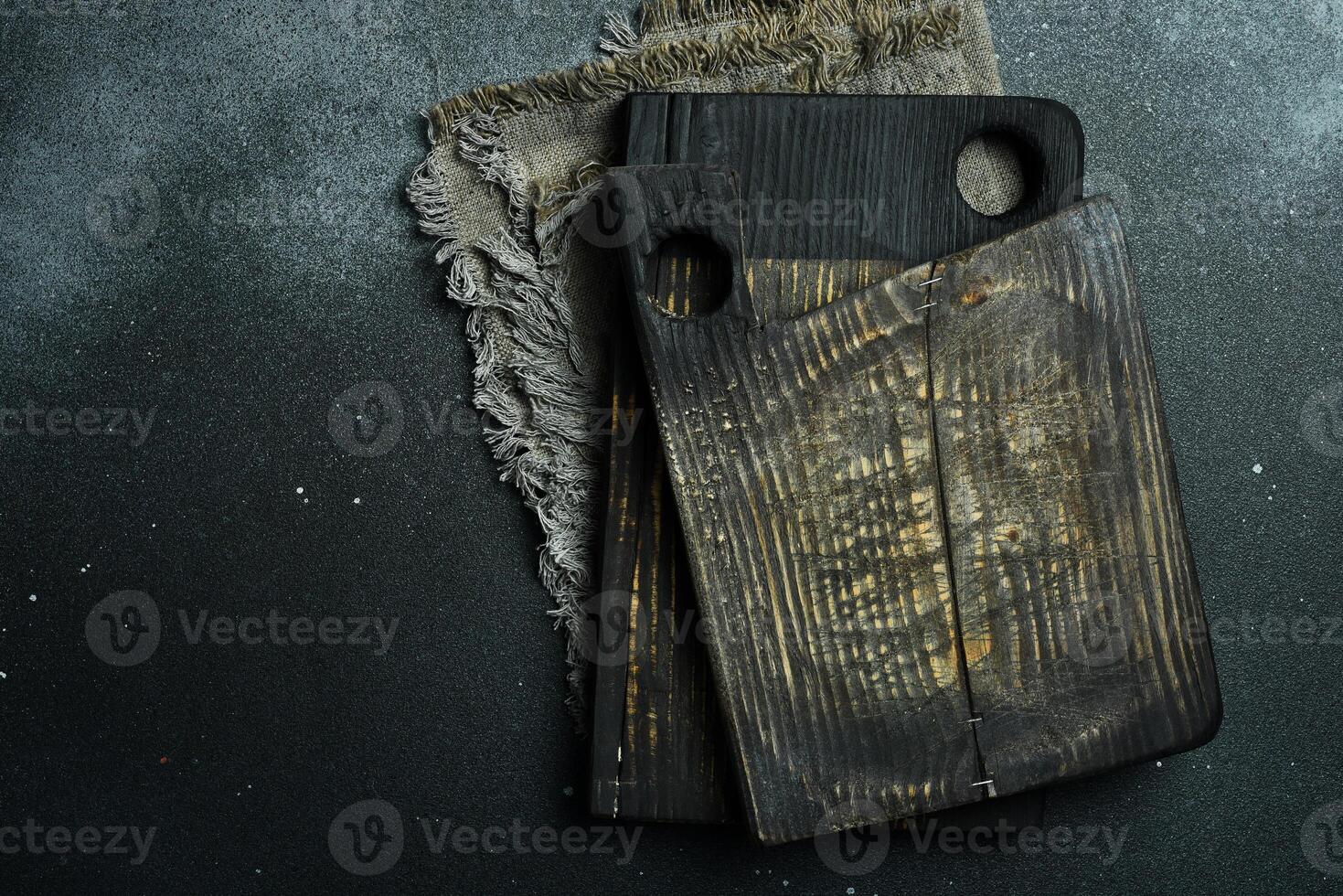 Kitchen old cutting board. Brown board. Kitchen utensils. On a dark background. photo