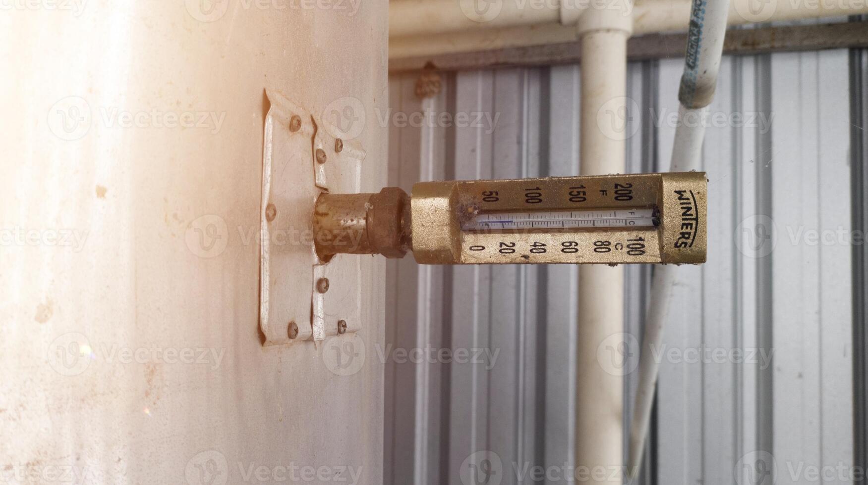 Gold thermometer instaled to boiler tank for measurment heat temperature. photo