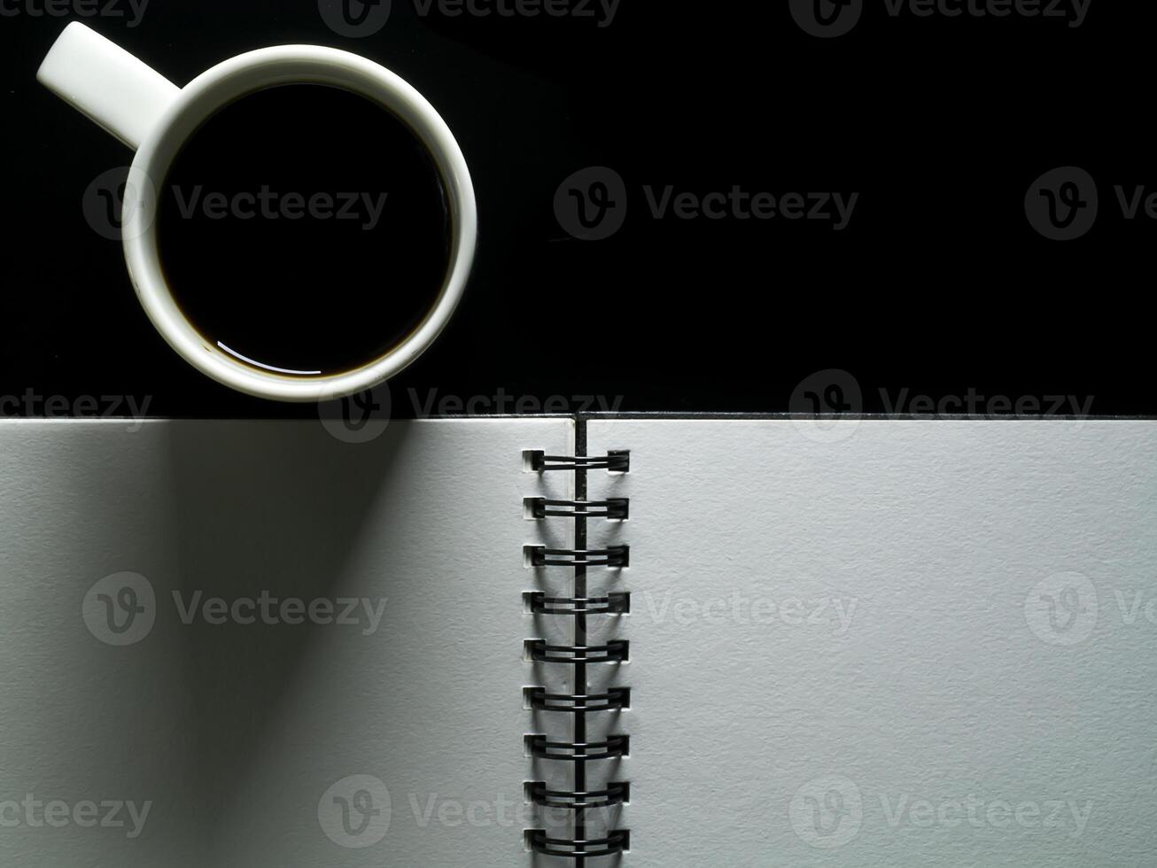 Close up blank page with coffee on black background. photo