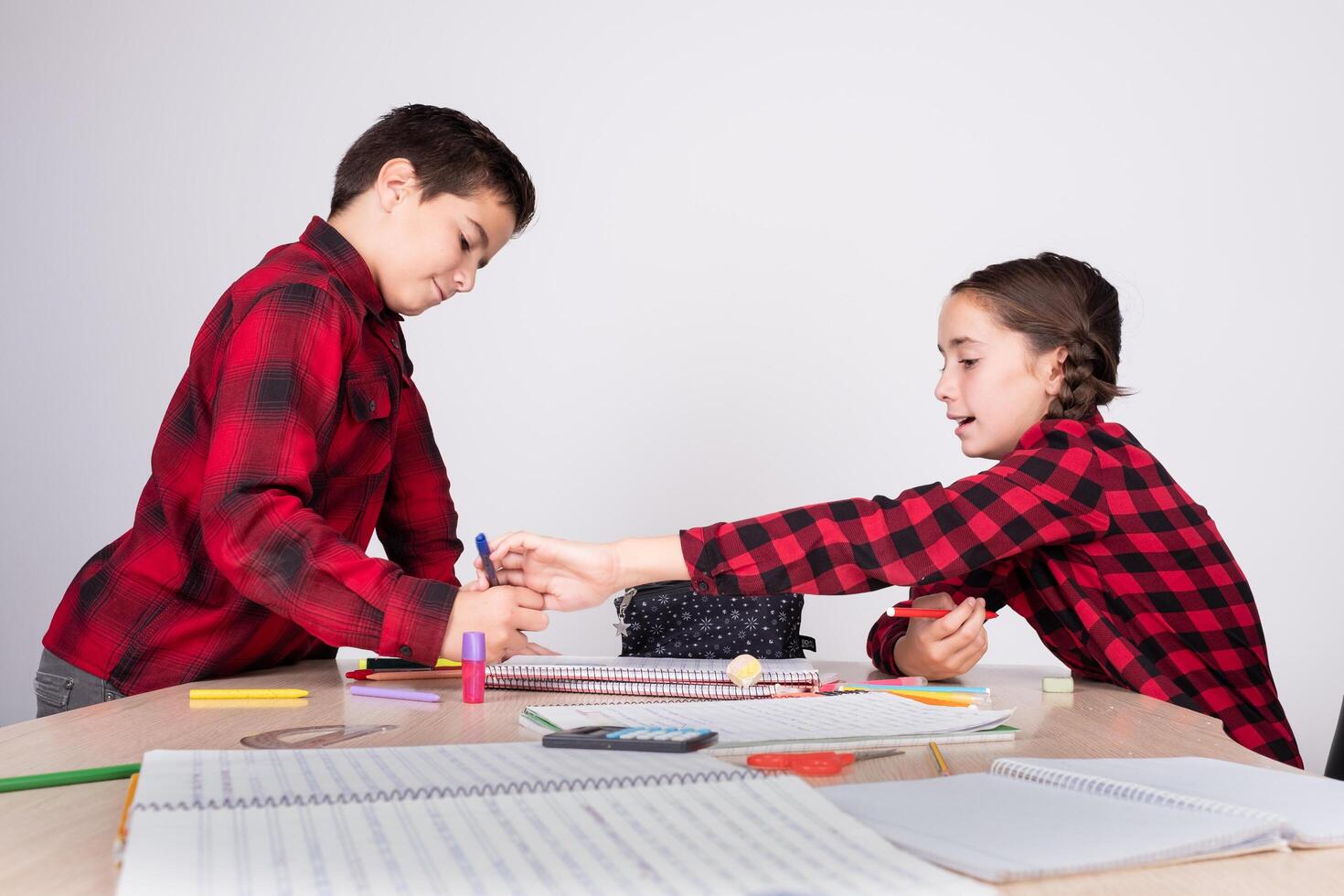 angry girl removing pencil from child at school photo