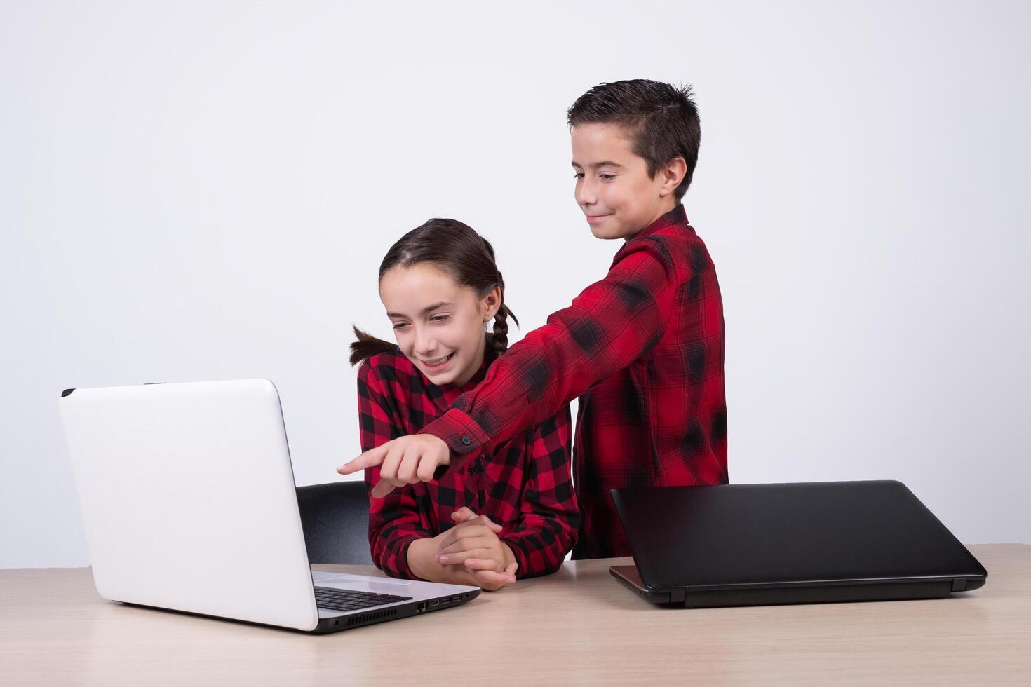 boy showing a computer game to girl in class photo