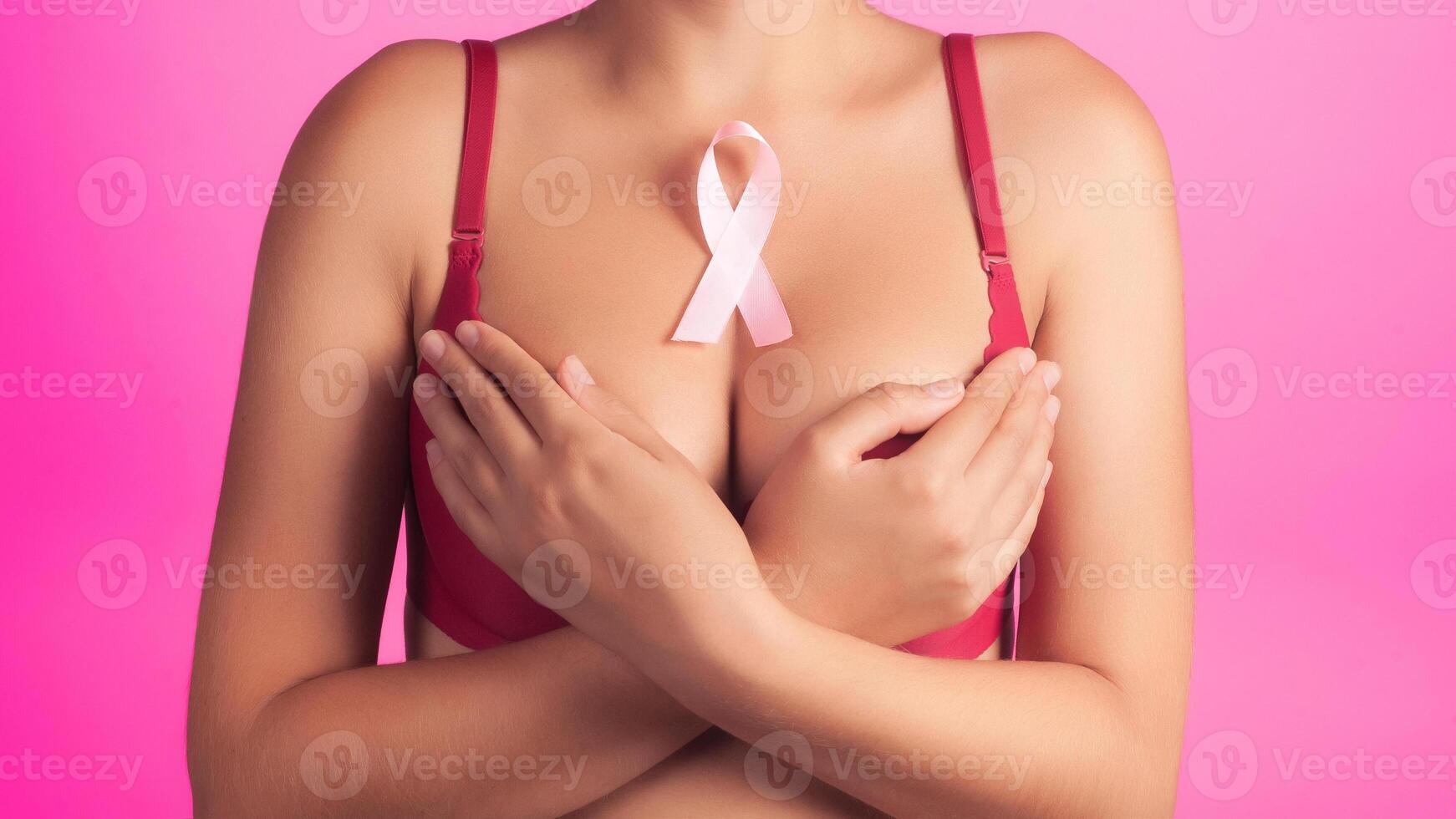 health, medicine, beauty concept - naked woman rad bra with Pink Breast Cancer awareness Ribbon. Support of patients with oncology. close-up background photo