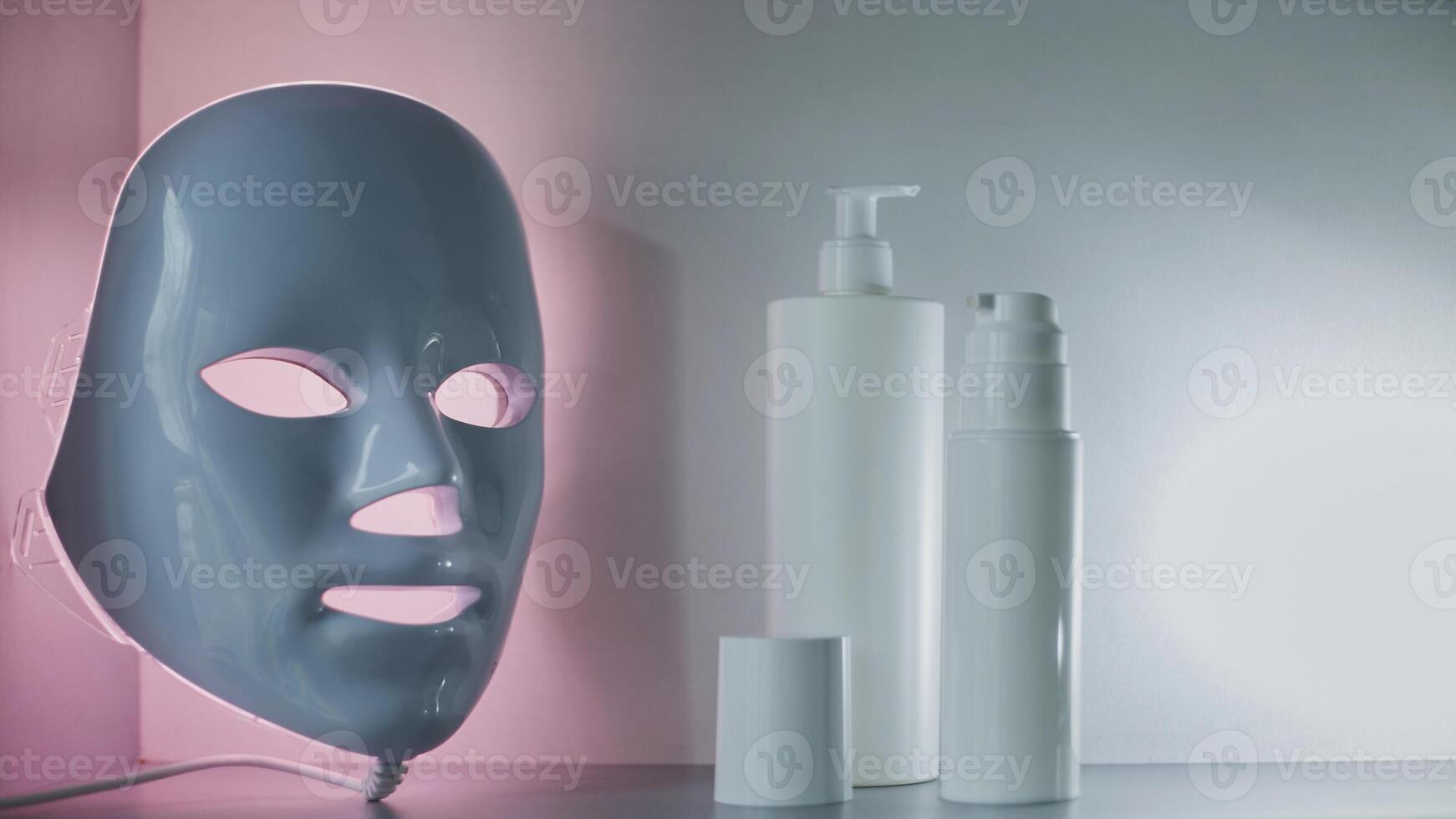 Light therapy LED mask on a shelf next to facial skin care products. photo