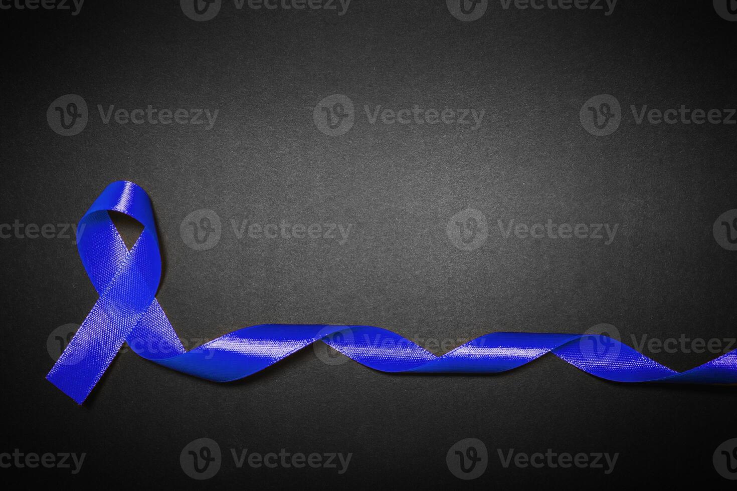 medicine, health care and symbolics concept - close up of blue prostate cancer awareness ribbon photo