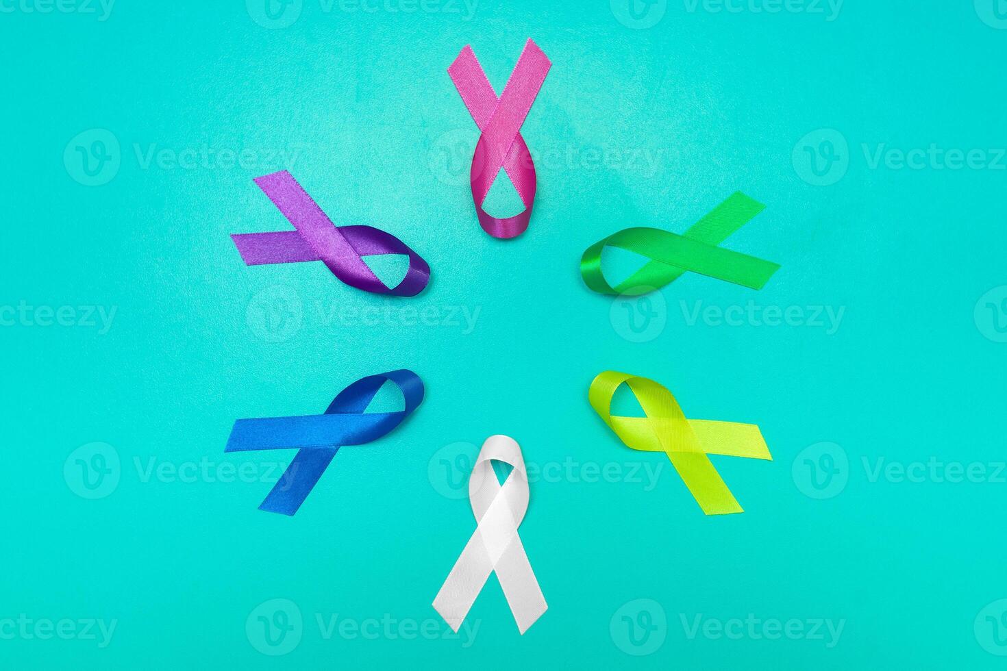 World cancer day background. Colorful ribbons, cancer awareness. blue surface from above. photo