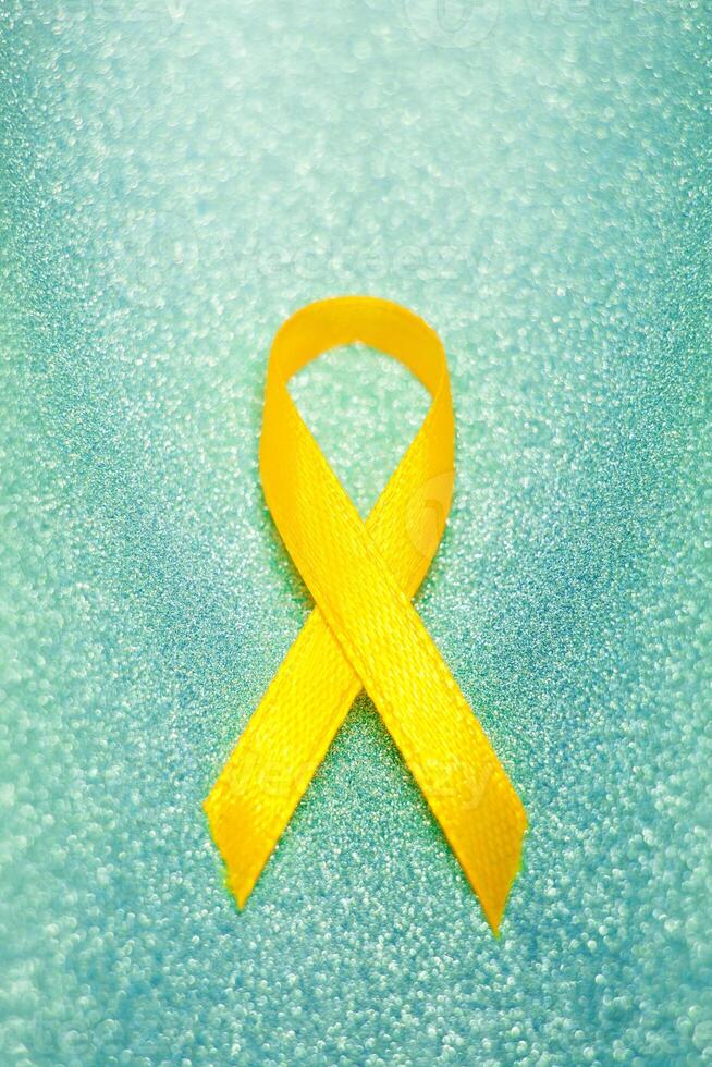 Gold ribbon for children as a symbol of childhood cancer awareness. World Cancer Day photo