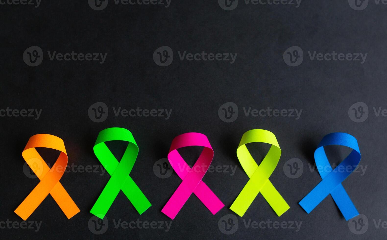 World cancer day background. Colorful ribbons, cancer awareness. On a black background photo