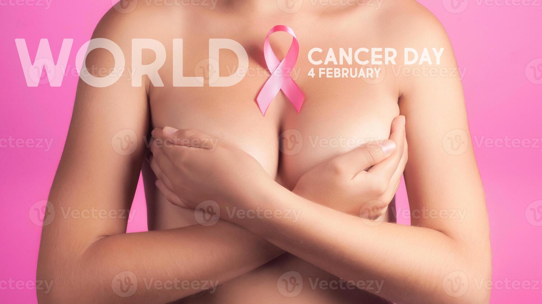 World cancer day concept background. Young woman examining her breast for lumps or signs of breast cancer. Pink Ribbon. photo