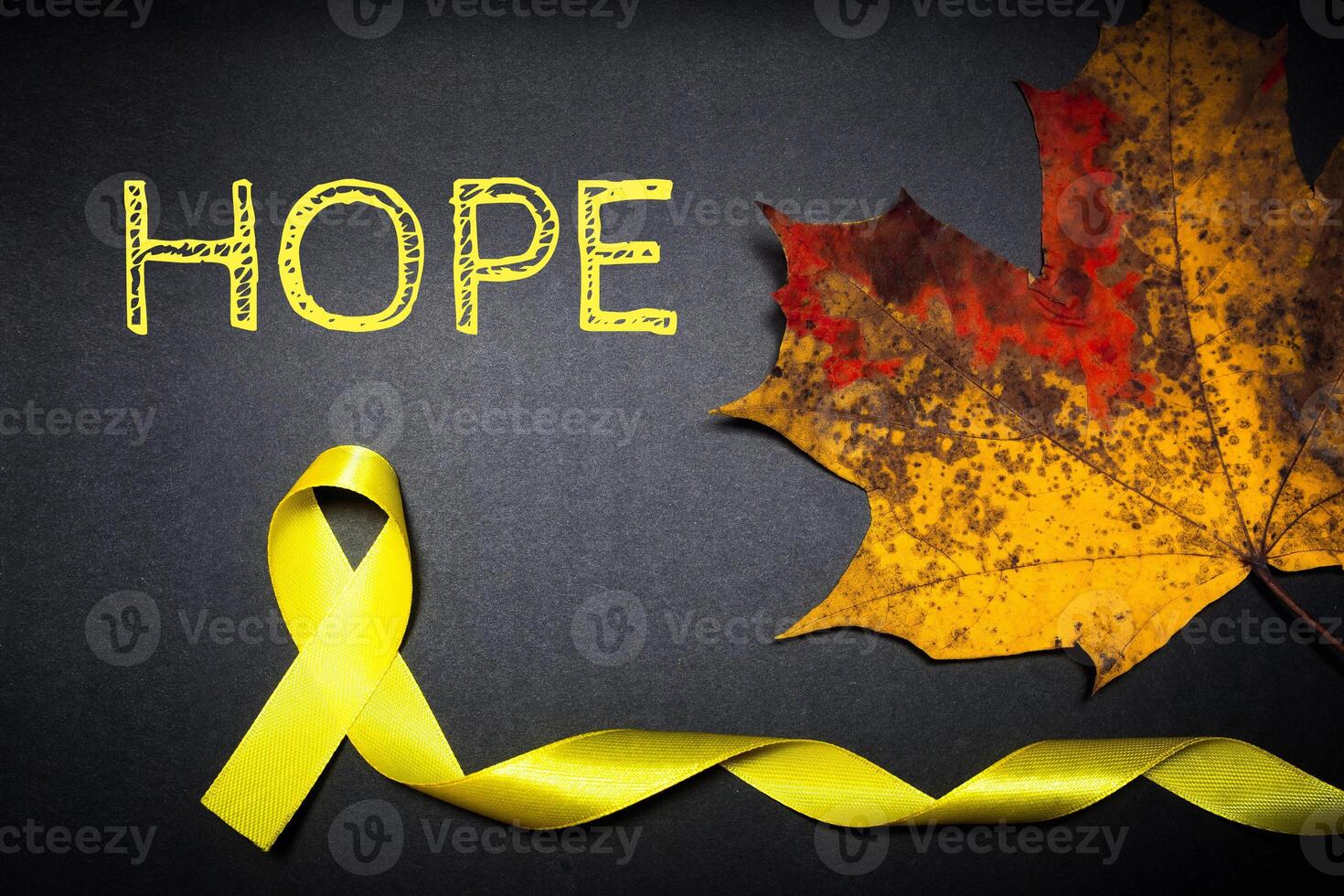 childhood cancer awareness day. Yellow ribbon on black background. photo